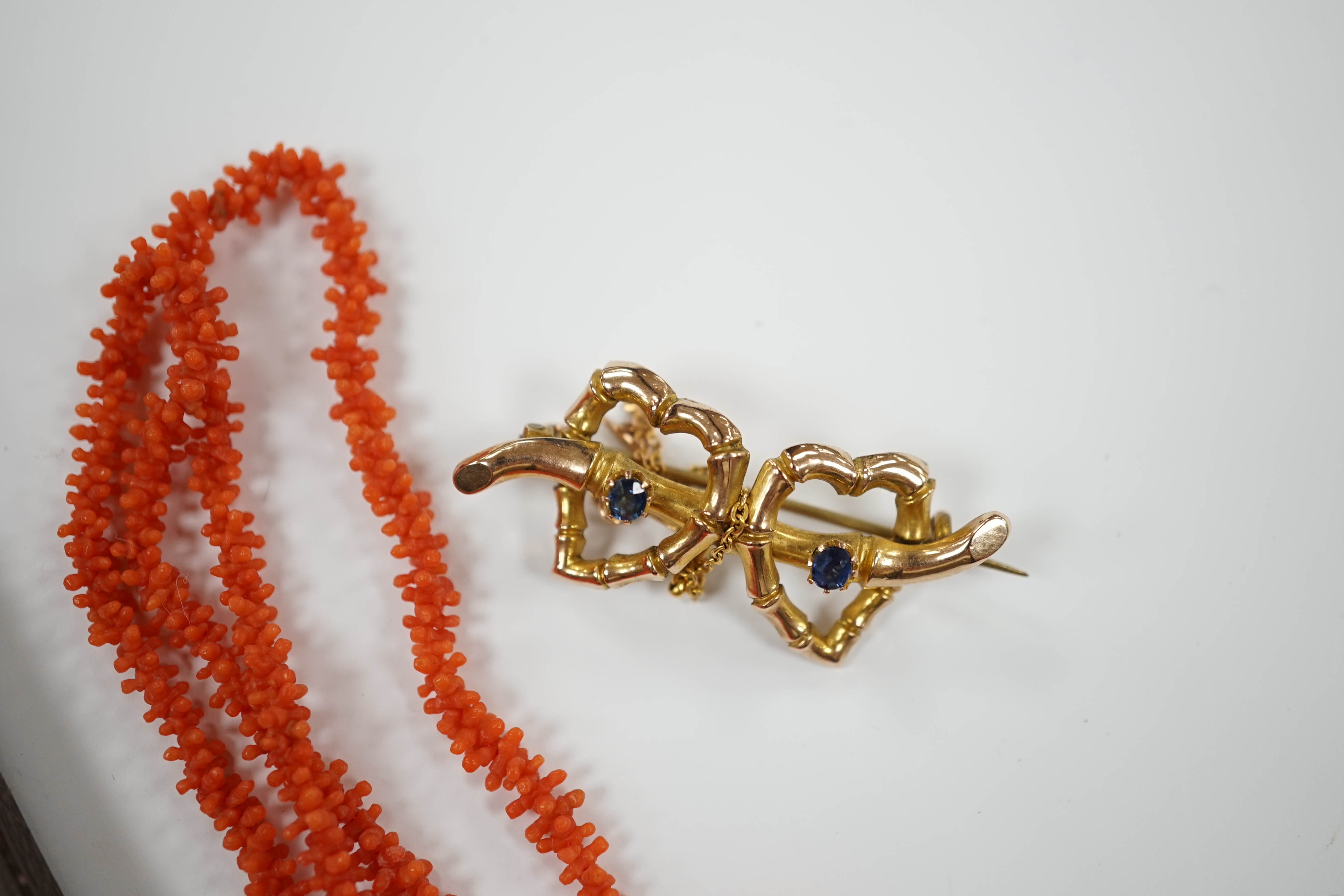 A suite of gilt metal and paste set jewellery, comprising a necklace and pair of earrings, a late Victorian 9ct gold and two stone sapphire set twin hearts brooch and a coral necklace.